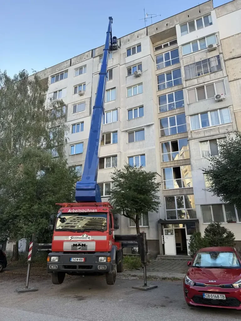 Автовишка със стрела, вдигната до панелен блок