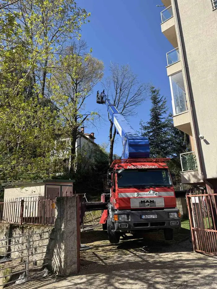 Автовишка в двор между сгради при рязане на дървета